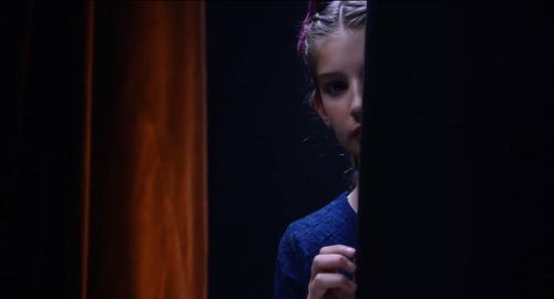 Olivia Valera (Lillian Blankenship) peeks into the talent show audience to see if her dad Frank (Antonio Banderas) made 