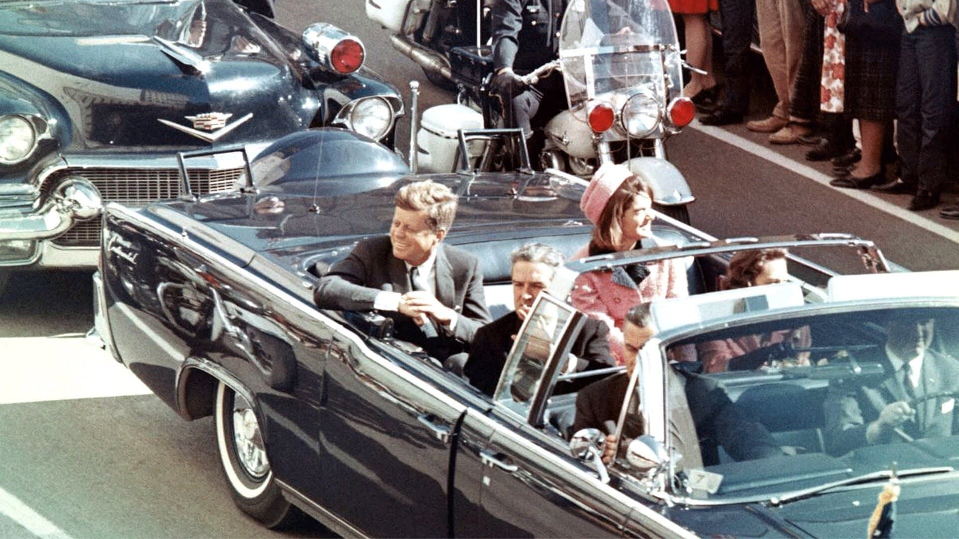 JFK Revisited: Through the Looking Glass background